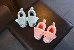 Detail view of cute cartoon shark plush slippers for kids in soft pink and mint green