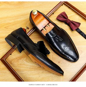 Detaillierte Makroansicht schwarzer Leder-Brogue-Loafer mit Quasten auf Holzoberfläche