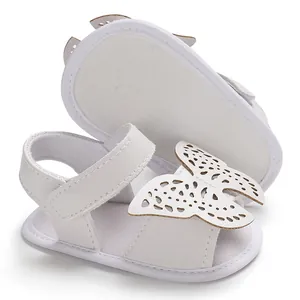 Vista detallada de sandalias blancas para bebé con un gran adorno decorativo de mariposa.