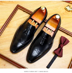 Klassische schwarze Budapester Lederschuhe mit Quasten und burgunderroter Fliege.