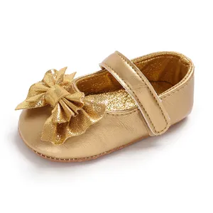 Chaussures de princesse pour bébé dorées brillantes avec gros nœud et bride velcro.
