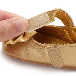 Gros plan détaillé d'une chaussure dorée pour bébé avec fermeture velcro pratique