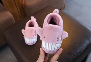 Cute pink shark plush slippers for kids featuring warm fleece lining and shark design