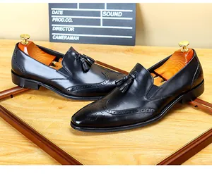 Nahaufnahme von schwarzen Brogue-Slippern aus Leder mit eleganten Quasten