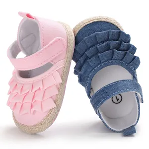 Close-up detail of ruffled canvas baby pre-walker shoes in pink and denim blue colors
