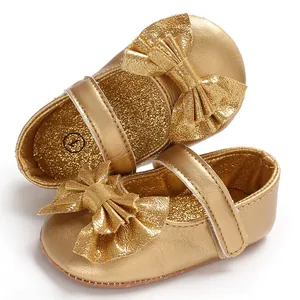 Macro shot détaillé de chaussures de princesse dorées pour bébé avec finition métallique et nœud