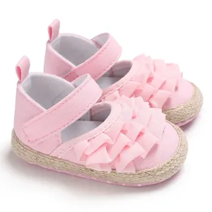 Close-up of pink ruffled princess baby walking shoes with soft soles and velcro