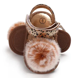 Close-up of baby leopard print sandals featuring a soft fluffy fur pom-pom detail