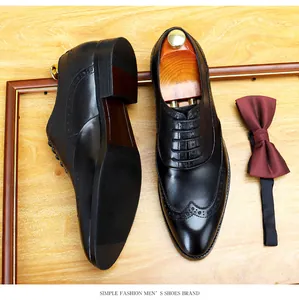 Primer plano de zapatos brogue de cuero negro para hombre con elegantes patrones perforados.