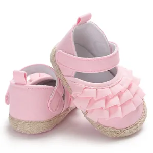 Close-up of pink ruffled baby girl Mary Jane shoes with soft braided soles