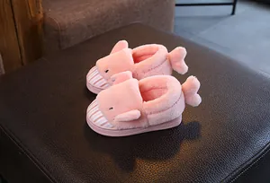 Detail view of pink plush shark-themed slippers for children with cozy faux fur
