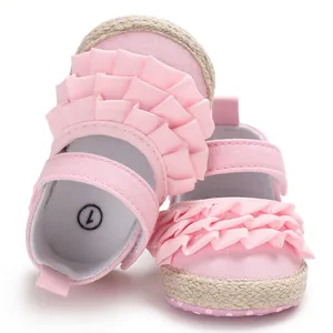 Detail of pink ruffle baby girl shoes with soft sole and decorative rope edge