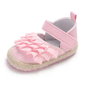 Close-up detail of pink baby girl walking shoes with ruffled layers and Velcro strap