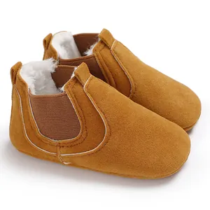 Warm yellow winter baby walking shoes with thick fleece lining and elastic side panels.