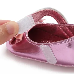 Détail en gros plan de la fermeture à scratch ajustable sur chaussures bébé roses