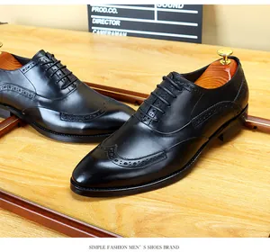 Vista detallada de zapatos oxford brogue de cuero negro en una mesa de madera.