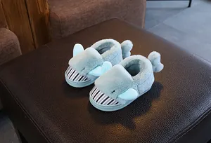 Detail shot of cute light blue dolphin plush slippers for children's winter wear