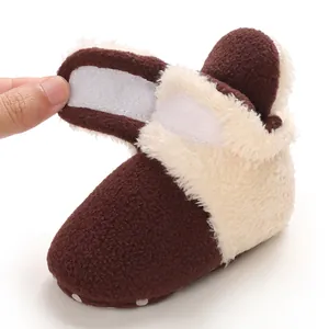 Detalle de bota de nieve marrón para bebé con forro de felpa y cierre de velcro