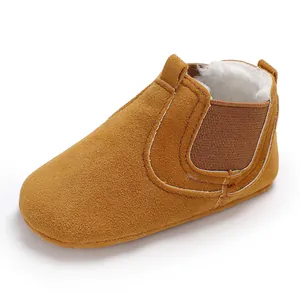 Macro view of tan baby winter boots with warm white fleece lining and soft sole.