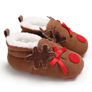Macro detail view of plush reindeer baby shoes featuring festive red bows and soft fur lining