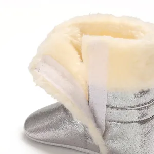 Gros plan d'une botte d'hiver argentée pour bébé avec doublure en fourrure et Velcro