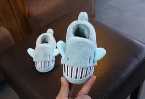 Macro view showing the soft texture of cute blue shark plush slippers for kids