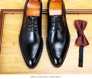 Elegante schwarze Herren-Lederschuhe mit Holz-Schuhspannern auf Holzfläche