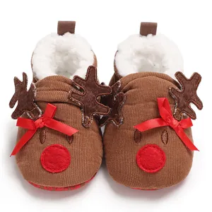 Detailed view of Christmas baby reindeer shoes with red bows and faux fur lining