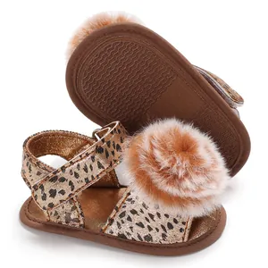Detail view of leopard print baby sandal with fuzzy pom-pom and non-slip sole.