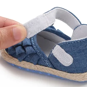 Close-up detail of the adjustable Velcro strap on these blue denim baby girl walking shoes