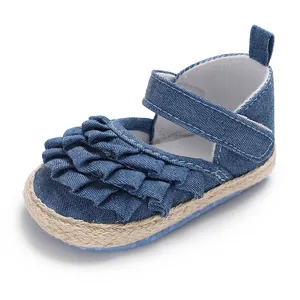 Detailed macro view of a blue denim baby girl shoe featuring soft ruffled layers and woven trim