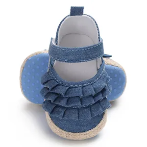 Detailed macro shot of blue denim baby shoes featuring ruffled wave layers and soft soles