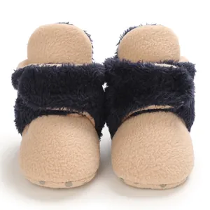 Vista frontal de botas de nieve para bebé con piel azul y suelas suaves antideslizantes