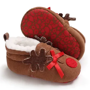 Detailed view of brown corduroy baby reindeer booties with red bow and fleece lining