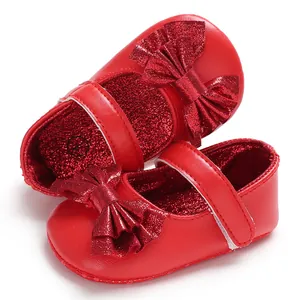 Détail en gros plan des chaussures de marche princesse rouge pour bébé avec nœud pailleté
