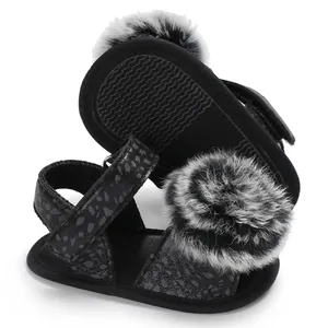 Detailed view of baby leopard sandals with fluffy faux fur pom-poms and soft non-slip soles.
