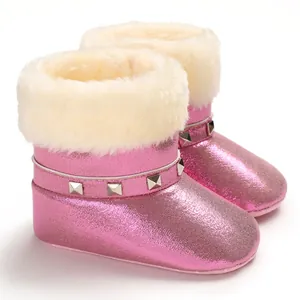 Gros plan de bottes de neige roses pailletées pour bébé avec bordure en fausse fourrure.