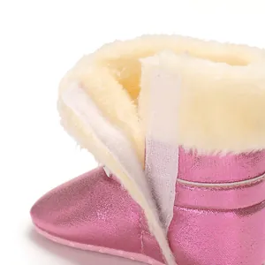 Gros plan de la doublure en fausse fourrure et du velcro sur des bottes de neige roses bébé