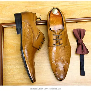 Vista dall'alto di scarpe eleganti da uomo con trama a coccodrillo e papillon marrone