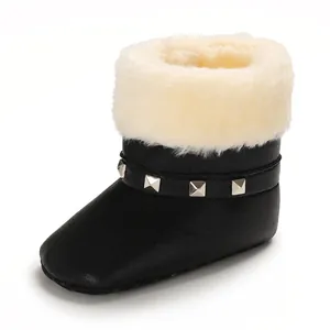 Gros plan détaillé de bottines de neige noires pour bébé avec fausse fourrure et clous