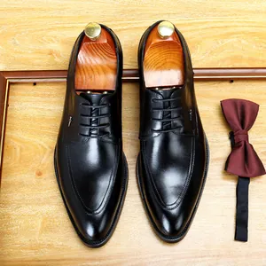 Klassische schwarze formelle Herren-Lederschuhe mit hölzernen Schuhspannern und Fliege