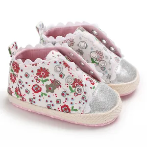 Detailed view of floral print baby sneakers with silver glitter toe caps and soft pink soles.