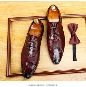 Dettaglio ravvicinato di scarpe eleganti marroni da uomo con motivo a pelle di coccodrillo