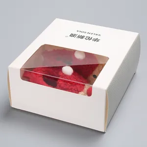 Close-up of soft sole Christmas baby plush shoes inside a white windowed gift box