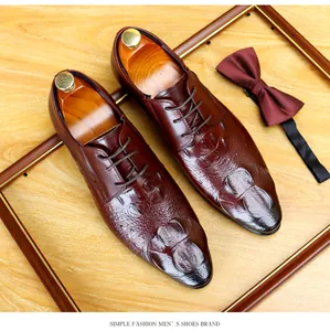 Dettaglio delle scarpe eleganti da uomo con trama a coccodrillo in bordeaux