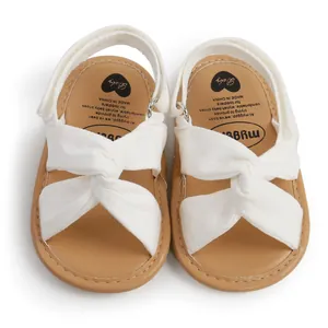Vista superior de adorables sandalias blancas para bebé con suelas blandas color beige