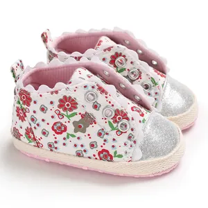 Detail view of floral baby girls' shoes with silver glitter toe caps and soft soles.
