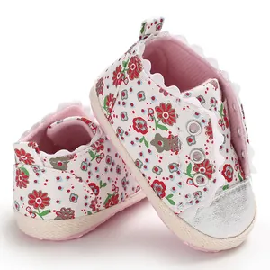 Close-up detail of floral print baby girl walking shoes with soft soles and lace trim