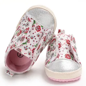 Detailed view of floral baby walking shoes with soft pink soles and silver toe caps.