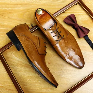 Scarpe stringate da uomo marroni in pelle con motivo a coccodrillo in un set elegante.